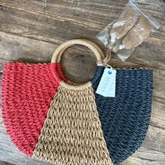 three different colored straw bags sitting on top of a wooden table