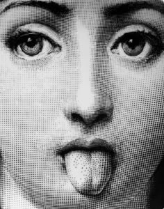 a black and white photo of a woman making a face with her tongue sticking out