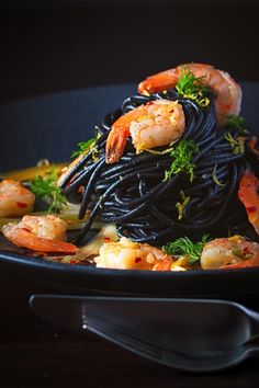 pasta with shrimp and black sauce in a bowl