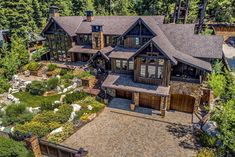 an aerial view of a large home surrounded by trees and rocks in the woods with lots of greenery