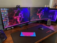 three computer monitors are sitting on top of a desk with keyboard, mouse and speakers