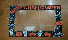 a halloween photo frame with pumpkins and ghostes on the front, sitting on a tile floor