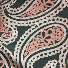 an image of a black and pink fabric with paisley designs on it's side