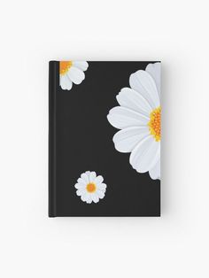 a black notebook with white and yellow flowers on it