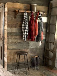 the coat rack is made out of wood and has three coats hanging from it's hooks