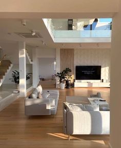 a living room filled with furniture and a flat screen tv on top of a wooden floor