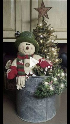 a teddy bear sitting in a bucket next to a christmas tree