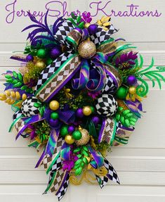 a purple and green christmas wreath on the front door