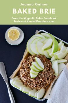 baked brie with apples and walnuts in a baking tin next to a spoon