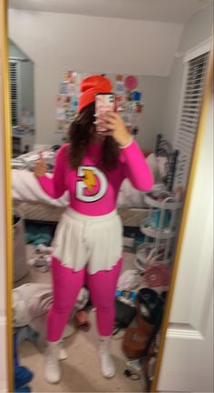 a woman in pink and white outfit taking a selfie