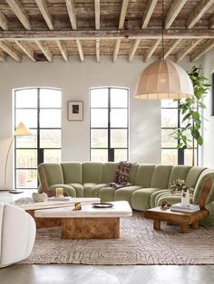 a living room filled with lots of furniture next to tall windows and large windows on the wall