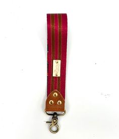 a red and brown striped lanyard with two metal hooks on it's side