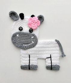 a crocheted cow with a pink flower on it's head is shown