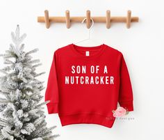 "Son Of  Nutcracker Kids Sweatshirt, Boys Christmas Sweatshirt, Toddler Sweatshirt, Kids Christmas Sweater, Youth Sweatshirt, Christmas Shirt Funny Christmas sweatshirt - perfect for upcoming sweater weather ♥ 📋 HOW TO ORDER: 1. Select the size 2. Select the color if required  3. Select the quantity 3. Add personalization if required 4. Add to Cart (\"buy now\" will take you directly to checkout and \"add to cart\" will allow you to continue shopping with us) 5. Submit order (Shipping will auto Funny Kids Christmas Shirts, Kids Christmas Shirts Vinyl, Boys Christmas Shirts, Toddler Christmas Sweater, Kids Christmas Sweater, Kids Christmas Shirts, Christmas Shirts Vinyl, Kids Christmas Shirt, Toddler Christmas Shirt