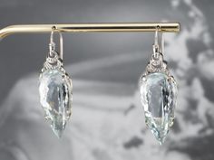 Utterly Breathtaking! These stunning aquamarine drop earrings have a striking presence! Sleek and glamorous, the elongated pear cut of the clear blue aquamarines creates a gorgeous line that draws the eye to the fiery scrolling diamond accents! Metal: 10K White Gold Gem: 2 Aquamarines totaling 48.99 Carats Gem Measurements: 31.1 x 14.1 mm, Pear Accents: 6 Diamonds totaling .10 Carats Earrings Length: 49.0 mm Earrings Width: 14.1 mm Elegant Light Blue Drop Jewelry, Elegant Aquamarine Earrings, Teardrop Aquamarine Jewelry For Formal Occasions, Aquamarine Teardrop Jewelry For Formal Occasions, Formal Teardrop Aquamarine Jewelry, Aqua Marine, Diamond Drops, Aquamarine Blue, Diamond Drop Earrings