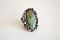 "This Native American ring features a large green turquoise stone in a large statement setting. The ring is in good condition with natural aged patina. Turquoise stone has an inclusion that is natural to the stone. Ring is signed \"B Sterling\" - possible Benjamin Piaso Navajo. Please checkout the similar turquoise stone cuff - different artisan - (ring and cuff are listed separately). size 7 1/2 1 5/8 inch tall 1 3/16 inch wide band is 1/2 to 3/4 inch thick I ship worldwide! Thanks for looking. Antique Turquoise Ring With Patina, Vintage Chrysocolla Turquoise Ring, Vintage Green Turquoise Ring With Inlay, Bohemian Turquoise Ring With Patina For Collectors, Turquoise Statement Ring, Contemporary Costumes, Native American Rings, Artisan Rings, Basic Jewelry