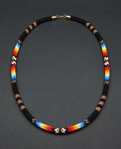 Add a touch of cultural flair with this ethnic beaded choker necklace. Inspired by Native American traditions, the intricate beadwork and unique design make it a standout piece of jewelry. Artisan Black Beaded Necklace Handwoven, Artisan Black Handwoven Beaded Necklace, Artisan Handwoven Black Beaded Necklace, Black Handwoven Beads For Festival, Festival Choker With Hand-strung Round Beads, Hand-strung Round Beads Choker For Festival, Bohemian Black Handwoven Beaded Necklaces, Hand-strung Choker With Round Beads For Festival, Handwoven Black Beads For Festival