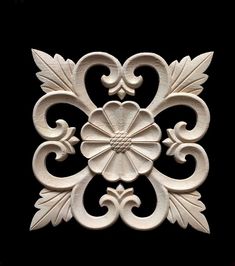 an intricately carved design on the side of a black wall with white flowers and leaves