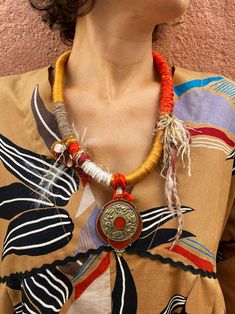 A very beautiful Tibetan pendant in ornate bronze and enamel! A large strap wound with different ocher, red, orange, ecru, coffee cotton and silk threads, with a few fringes accompanied by copper coins. Closing with a button. Be unique! Each piece of jewelry only exists in one copy and you will be the only one to wear it. The pendant: in crafted brass with an orange enamel cabochon, which is also found all around (diameter 5 cm). The strap: on a cotton pilou backing, I securely rolled up differe Copper Coins, Silk Thread, Lanyard, Necklace Etsy, Jewelry Necklace Pendant, Statement Necklace, Jewelry Necklaces, Accessory Gift, Buckle