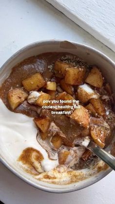 a bowl filled with food sitting on top of a white counter next to a window