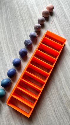 an orange plastic tray filled with different colored rocks