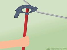 a hand holding a red pole with a metal hook attached to it and the handle is bent down