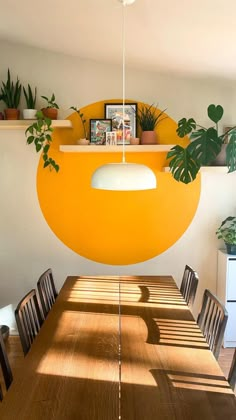 a dining room table with chairs and a large yellow object hanging from it's ceiling