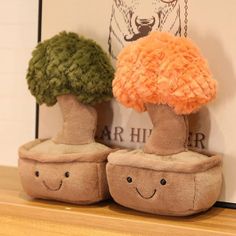 two stuffed mushrooms sitting on top of a wooden shelf