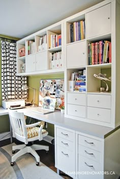 a white desk sitting under a window next to a bookshelf filled with books