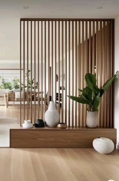 a living room with wooden slats and white vases