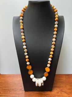 ORANGE SPICE:  LOOOOooooong necklace statement piece.  Agate orange/white beads.  Focal point of glass beads with lava bead texture in white with white shell loops.  The loops sometimes bunch in the center or spread themselves across the lava beads.  The four orange irregular coin beads are Premium Picasso Czech glass.   I imagine this on a white dress but the complement of orange is blue, particularly denim is awesome. If you wish a longer or shorter necklace, please ask.  $3 charge for changes Unique Orange Agate Necklace, Artisan White Gemstone Beads Necklaces, Artisan White Necklaces With Gemstone Beads, Artisan White Necklaces With Natural Stones, White Agate Necklace For Jewelry Making, White Agate Beaded Necklaces With Natural Stones, White Agate Beaded Necklace With Natural Stones, White Agate Gemstone Beads Necklaces, White Agate Necklace With Round Beads