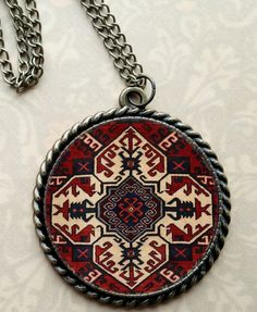 a red, white and black medallion on a chain