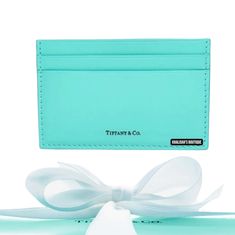 a blue card case with a white bow on it and a tag attached to the front