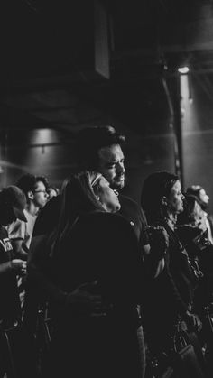 black and white photograph of people sitting in a row talking on cell phones at an event