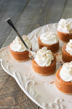 small desserts on a white plate with a fork in the middle and whipped cream on top