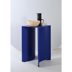 a blue side table with a bowl on it