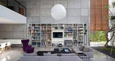 a living room filled with lots of furniture and bookshelves next to a window