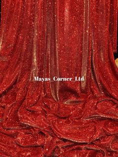 a teddy bear sitting on top of a red cloth covered stage with the words mayos corner ltd