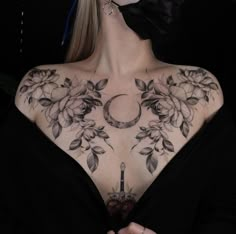 a woman with tattoos on her chest wearing a black mask and bow in front of her face