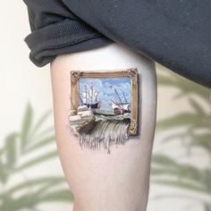 a woman's leg with a painting on the side of her thigh that has an image of boats in it