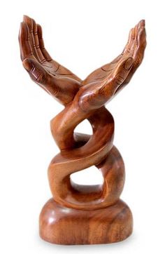 a wooden sculpture with two hands on top of each other and a snake in the middle