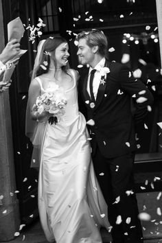 a bride and groom are walking through confetti as they exit the church together