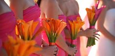 bridesmaids in pink dresses holding orange flowers