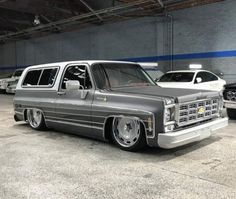 a silver truck parked in a garage next to other cars