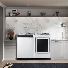 a washer and dryer in a kitchen with marble wallpaper on the walls