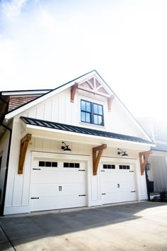 a large white house with two garages on each side