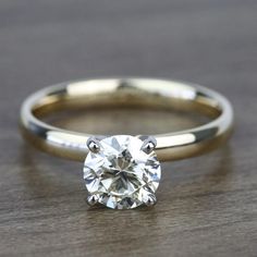 a close up view of a diamond ring on a table with the center stone in yellow gold