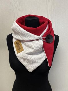 a white and red scarf on a mannequin's head with a black button