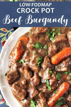 a white plate topped with beef and carrots covered in gravy on top of a blue table cloth