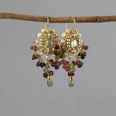 "Wedding Earrings, Maharaja Pearl Labradorite Earrings, Statement Earrings, Cluster Earrings, Chunky Earrings, Big Earrings, Gemstone Earring These rich and glamorous handcrafted Maharaja earrings feature silver and gold filled, set with natural labradorite, and a gentle setting of gold filled, freshwater pearl and tourmaline gemstones around it. The earrings are inspired by the Indian maharaja jewelry collections, characterized by rich and graceful design.  Maharaja is a Sanskrit title for a \"great king\". A matching necklace is available, please contact me for a custom order.  Labradorite properties: Transformation, Promotes psychic abilities, Strengthens our will, Stimulates imagination, Calming Materials: Metals: silver and gold filled Gemstones: tourmaline, freshwater pearl  Measurem Gold Bohemian Earrings With Gemstone Accents, Fine Jewelry Yellow Gold Earrings With Natural Stones, Yellow Gold Multi-stone Fusion Earrings, Fusion Style Multi-stone Yellow Gold Earrings, Gold Multi-stone Chandelier Earrings As Gift, Gold Multi-stone Chandelier Earrings For Gift, Yellow Gold Multi-stone Earrings For Wedding, Yellow Gold Fusion Earrings With Gemstone Accents, Fusion Yellow Gold Earrings With Gemstone Accents